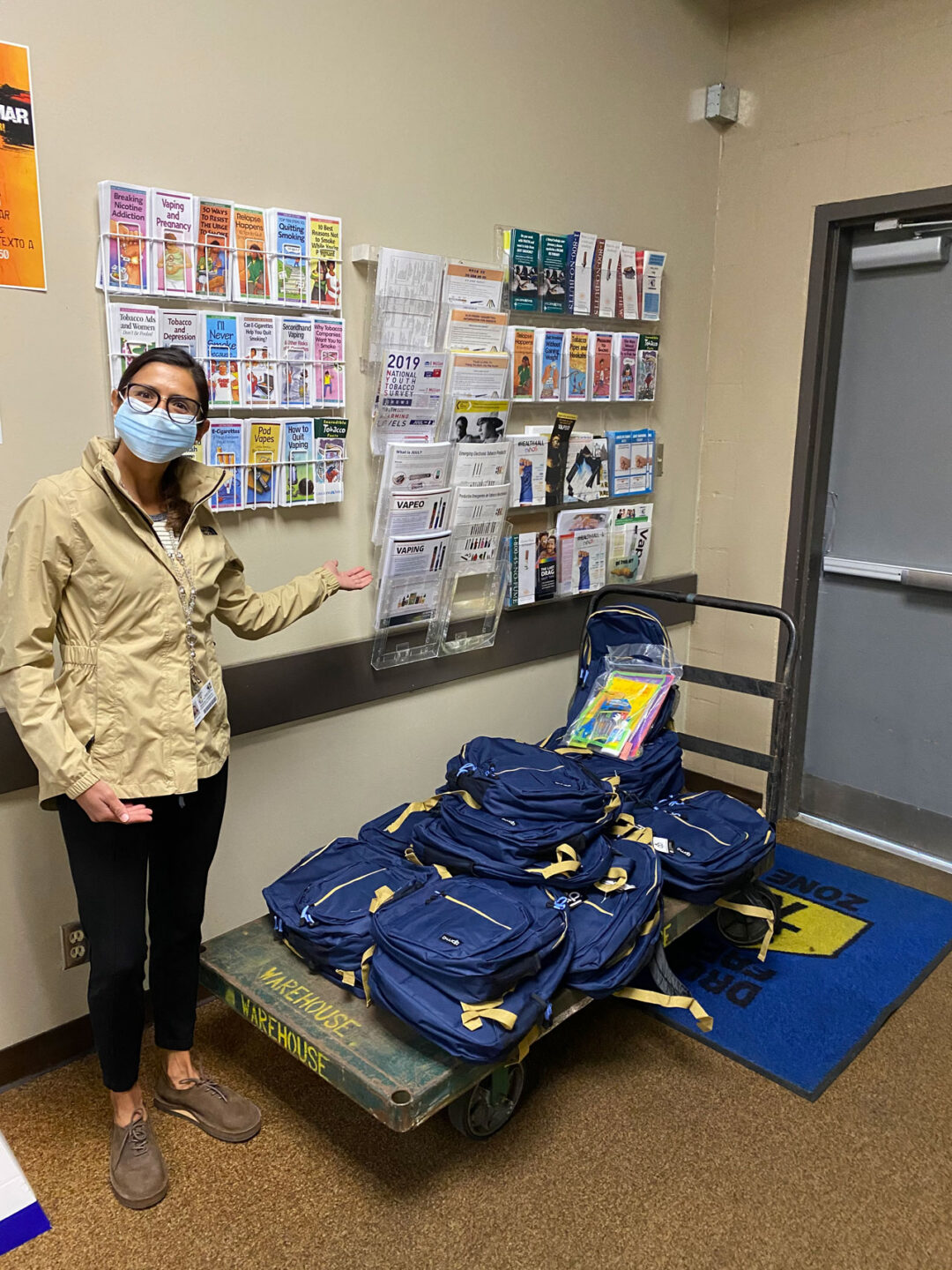 Staff member presenting backpacks and brochures