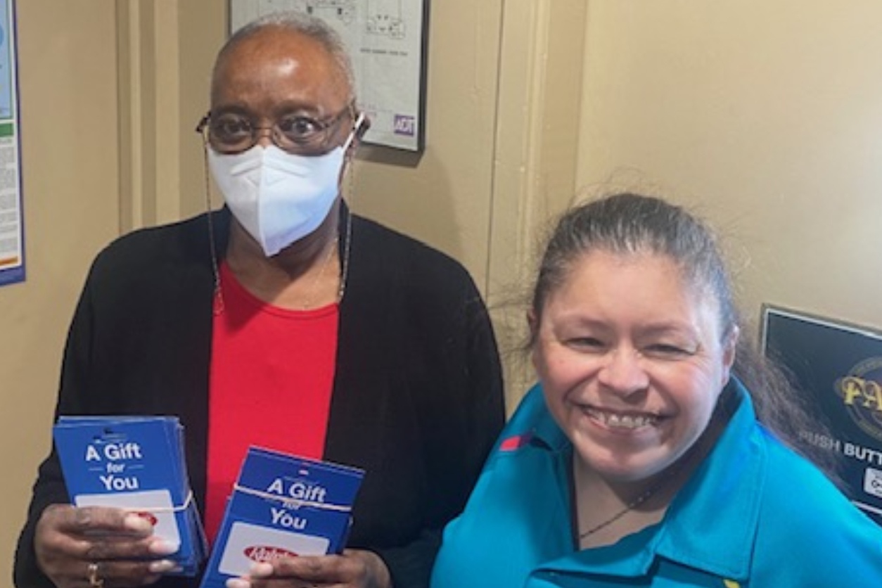 two women, one holding gift cards